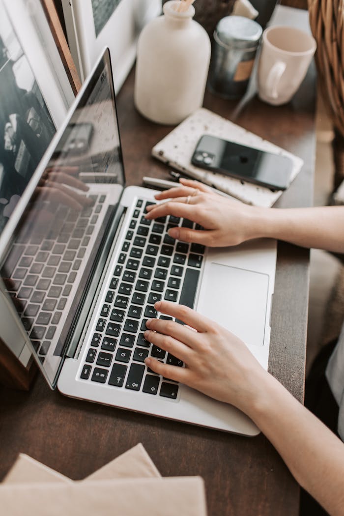 The Art of Drawing Readers In: Your attractive post title goes here From above of unrecognizable woman sitting at table and typing on keyboard of computer during remote work in modern workspace